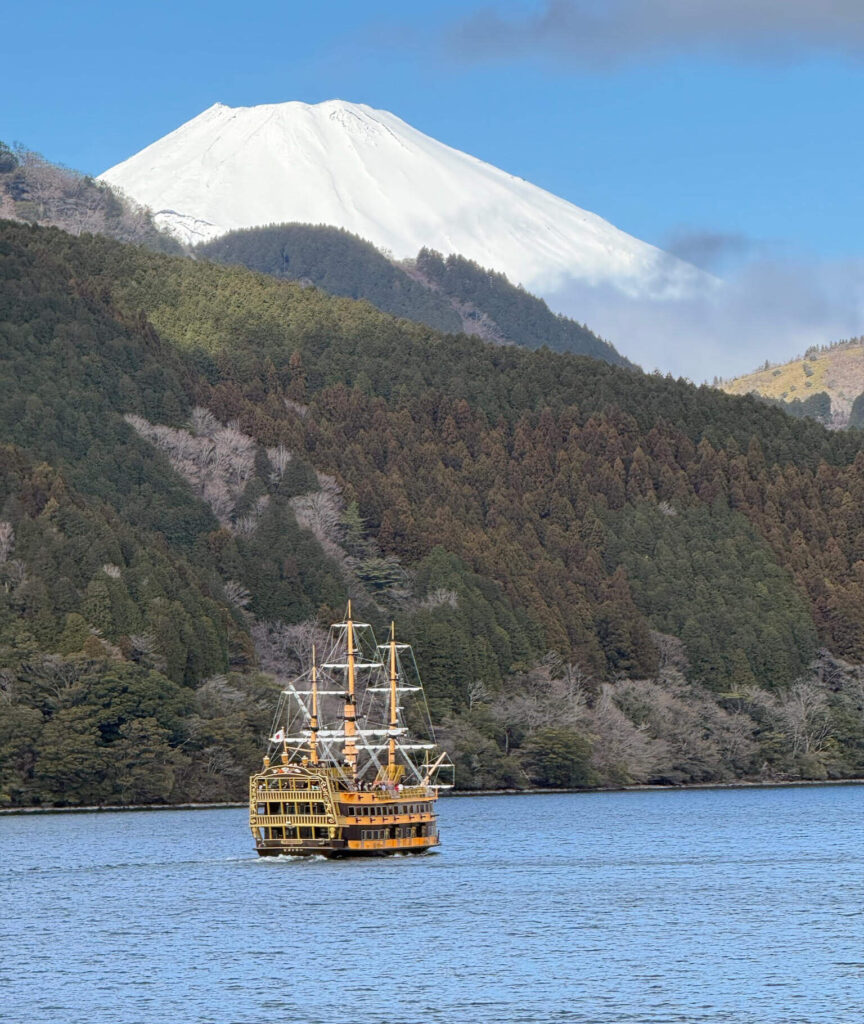 Pirate sightseeing ship on Lake Ashi with snow-capped Mount Fuji rising behind the hills
