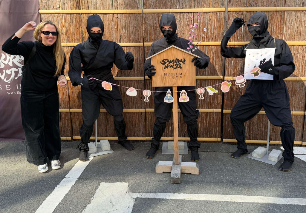 Posing with three ninja mannequins beside the Samurai Ninja Museum Kyoto sign